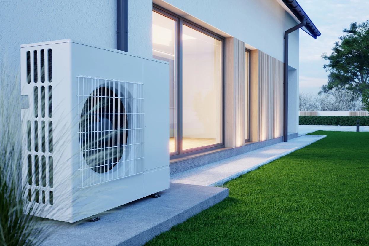 Extérieur résidentiel moderne au crépuscule avec pompe à chaleur air-eau installée sur terrasse béton