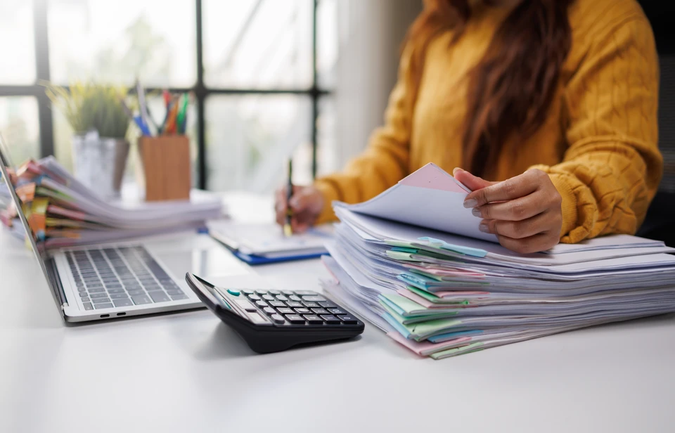 Gros plan sur un espace de travail administratif propre et organisé : bureau avec ordinateur portable affichant un formulaire ou un document officiel, dossier ouvert avec documents classés, stylo, calendar ou checklist complétée. L'ambiance doit être professionnelle, sereine et organisée, suggérant une gestion administrative complète et sans complications. Aucune personne visible. Éclairage naturel professionnel.